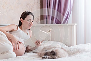 The pregnant young woman read in a bedroom