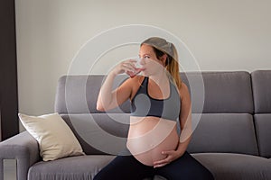 Pregnant young woman sitting and drinking a natural juice