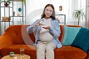 Pregnant young woman taking drug drinking water to nourish unborn child healthy pregnancy concept