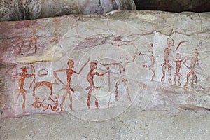 Prehistoric painting by primitive local caveman on the stone wall showing the hunting and civilization over 4000 years, Thailand