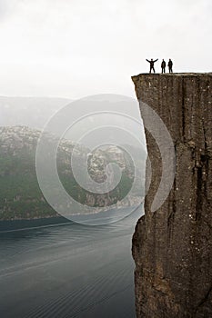 Preikestolen - amazing rock in Norway. Girl standing on a cliff above the clouds