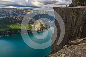 Preikestolen - landscape of tourists at the top of spectacular Pulpit Rock cliff and surrounding fjords, Norway