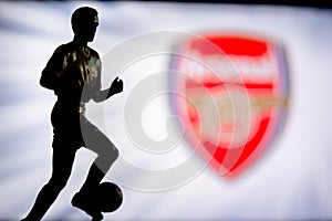 LONDON, ENGLAND, JULY. 1. 2019: Arsenal Football club logo, Premier League, England. Soccer player silhouette