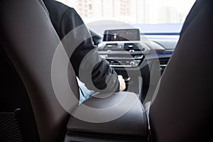 premiium driving. view from the back seat of a modern premium car. the driver sits behind the steering wheel, in front of him the