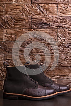 Premium Dark Brown Grain Brogue Derby Boots Made of Calf Leather with Rubber Sole Placed Over Grunge Background