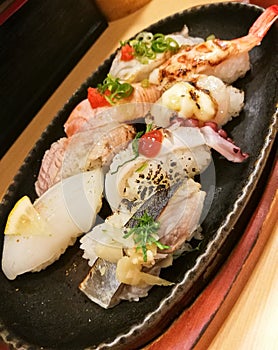 Premium fresh seafood sushi served in black platter.