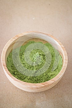 Premium green tea powder in wooden bowl