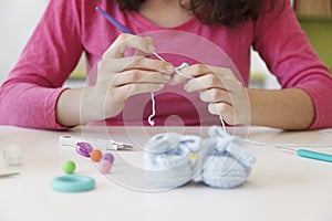 Prenatal mother creating woolen bootees for her baby