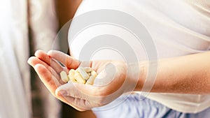 Prenatal vitamins pill. Happy smiling woman taking pill with supplement vitamin Omega 3. Vitamin D, E, A Fish Oil