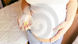Prenatal vitamins pill. Happy smiling woman taking pill with supplement vitamin Omega 3. Vitamin D, E, A Fish Oil
