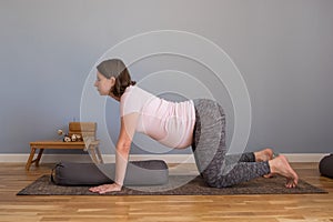 Prenatal yoga meditation. Pregnant woman doing yoga meditation at home