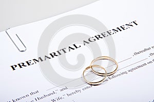Prenuptial Agreement form and two wedding rings photo
