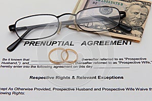 Prenuptial Agreement form and two wedding rings photo