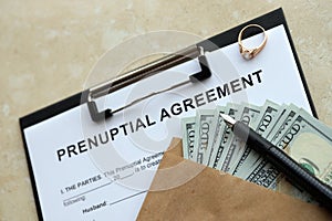 Prenuptial agreement and wedding ring on table. Premarital paperwork process in USA