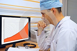 Preoccupied doctor looks at a growing chart photo