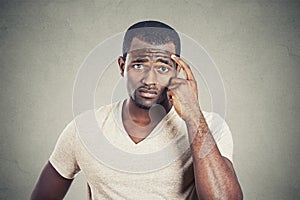 Preoccupied man scratching his head looking for solution photo