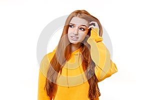 Preoccupied young redhead woman girl in casual yellow hoodie posing isolated on white background studio portrait. People