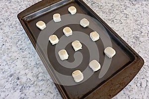 Prepackaged sugar cookies on a metal cookie sheet ready to be put in the oven
