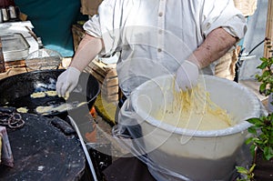 Preparacion deep fried fritters donuts in market photo