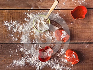 Preparation for baking holiday cookies, flour in a clay jar with a wooden spoon and silicone shaped molds