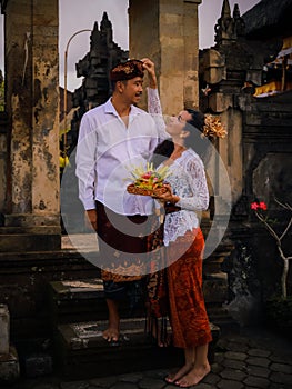 Preparation for Balinese ceremony. Multicultural couple preparing for Hindu religious ceremony with god`s offerings. Caucasian