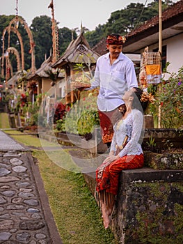 Preparation for Balinese ceremony. Multicultural couple preparing for Hindu religious ceremony with god`s offerings. Caucasian