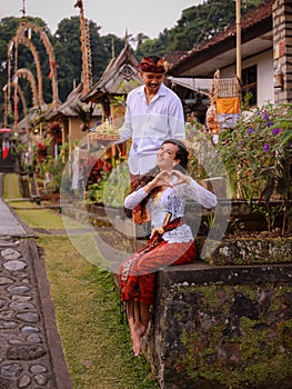 Preparation for Balinese ceremony. Multicultural couple preparing for Hindu religious ceremony with god`s offerings. Caucasian