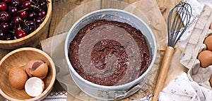Preparation of a chocolate cake with a cherry. Traditional American cake. Ingredients for baking. banner.