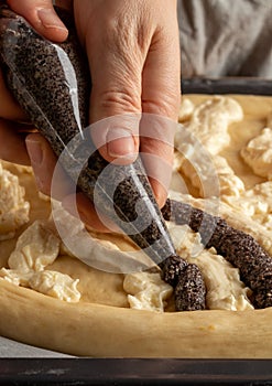 Preparation of Chodsky kolac - creating a pattern using ground poppy seeds and curd