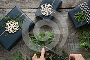 Preparation for Christmas. Workshop of decoration gift box from twine, branch and snowflakes. Woman prepare a present. Top view an