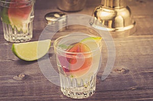 preparation of cocktail with a lime in a shaker/preparation of cocktail with a lime in a shaker on a wooden background. selective