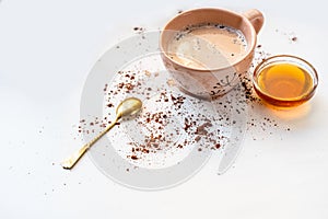 Preparation of cocoa drink, cup, honey, spoon and sprinkled cocoa powder