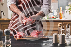 Preparation of dinner. Cooking, processing of meat beef, tenderloin . Person man`s hands marinates meat - sprinkles with