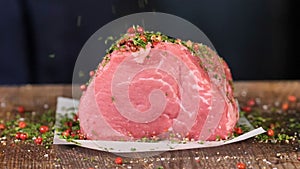 Preparation of dinner. Cooking, processing of meat beef, tenderloin. Person man`s hands marinates meat - sprinkles