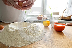 Preparation of dough, flour, eggs and wooden rolling pin on gray background