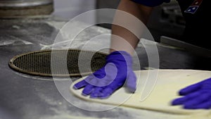 preparation of dough for pizza. Cooking pizza in a restaurant. hands of chef with gloves on