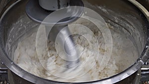 Preparation of dough in production with a professional dough mixer. Industrial mixer for kneading dough.