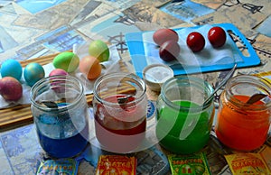 Preparation for the Easter holiday. Coloring chicken eggs in different colors in glass jars with food dye.