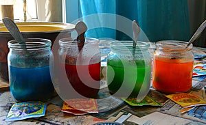 Preparation for the Easter holiday. Coloring chicken eggs in different colors in glass jars with food dye. In house conditions. Si