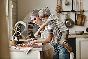 Preparation of family breakfast. mother and child son cut bread   in morning