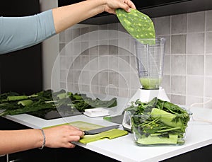 Preparation of green juice in the kitchen with blender nopales are cut on chopping board as an ingredient in a nutritious and heal