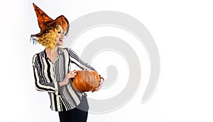 Preparation for Halloween holiday. Happy woman in witch hat with pumpkin. Emotional girl witch in magic hat with jack-o