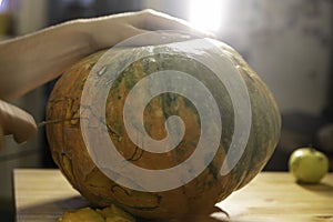 Preparation for the holiday. The process of carving a Halloween pumpkin with a knife