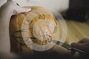 Preparation for the holiday. The process of carving a Halloween pumpkin on the table