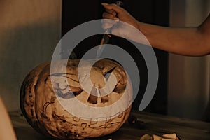 Preparation for the holiday. The process of carving a Halloween pumpkin on the table