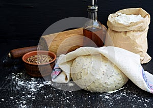Preparation of homemade bread from whole wheat flour and flax seeds on a dark wooden background. Copy space. Photographing with na