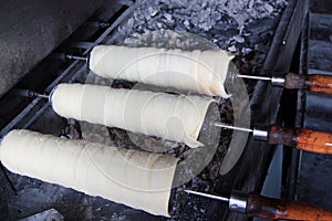 Preparation of the Hungarian traditional kurtos kalacs roasted over charcoal