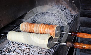 Preparation of the Hungarian traditional kurtos kalacs roasted over charcoal