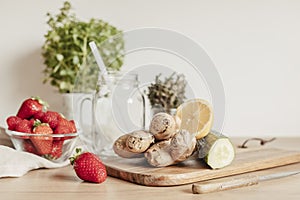 Preparation of infused water with cucumber, lemon and ginger in glass jar for detox