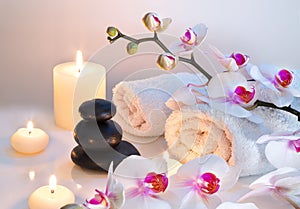 Preparation for massage with two towels, stones, candles and orchid